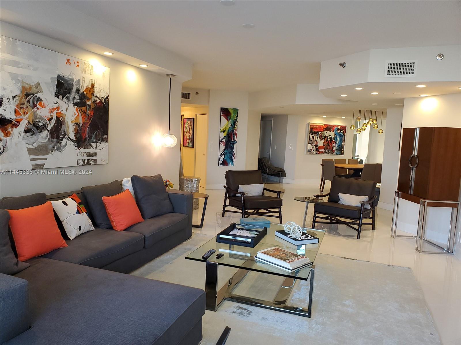 3000 Island Boulevard, Unit 2603 Aventura, FL 33160 - Photo 2 of 28 a living room with furniture flat screen tv and a large window