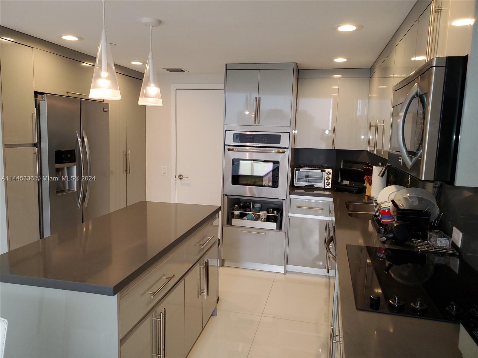 3000 Island Boulevard, Unit 2603 Aventura, FL 33160 - Photo 7 of 28 a kitchen with stainless steel appliances granite countertop a refrigerator and a stove top oven