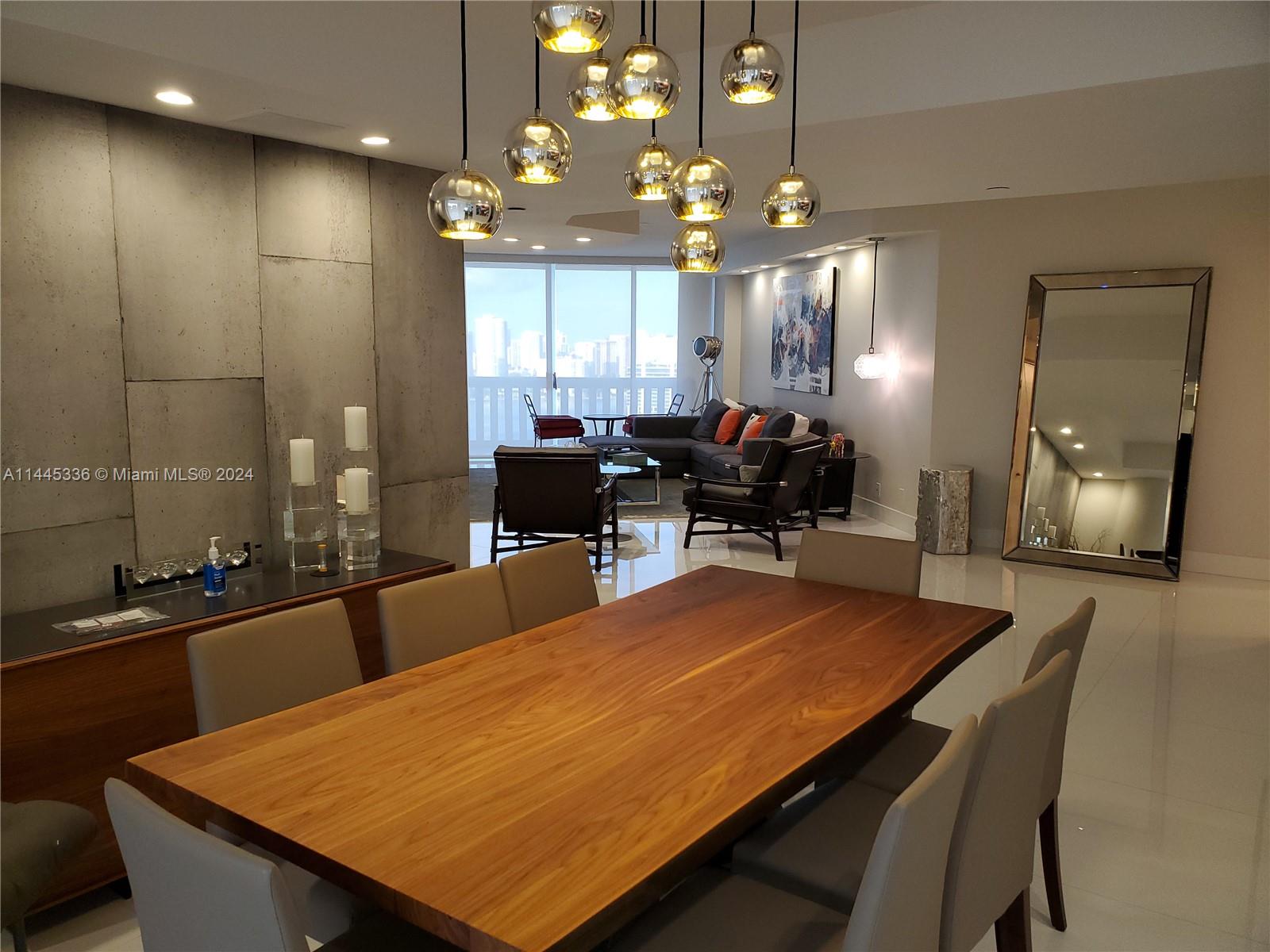 3000 Island Boulevard, Unit 2603 Aventura, FL 33160 - Photo 8 of 28 a kitchen with kitchen island a sink table and chairs