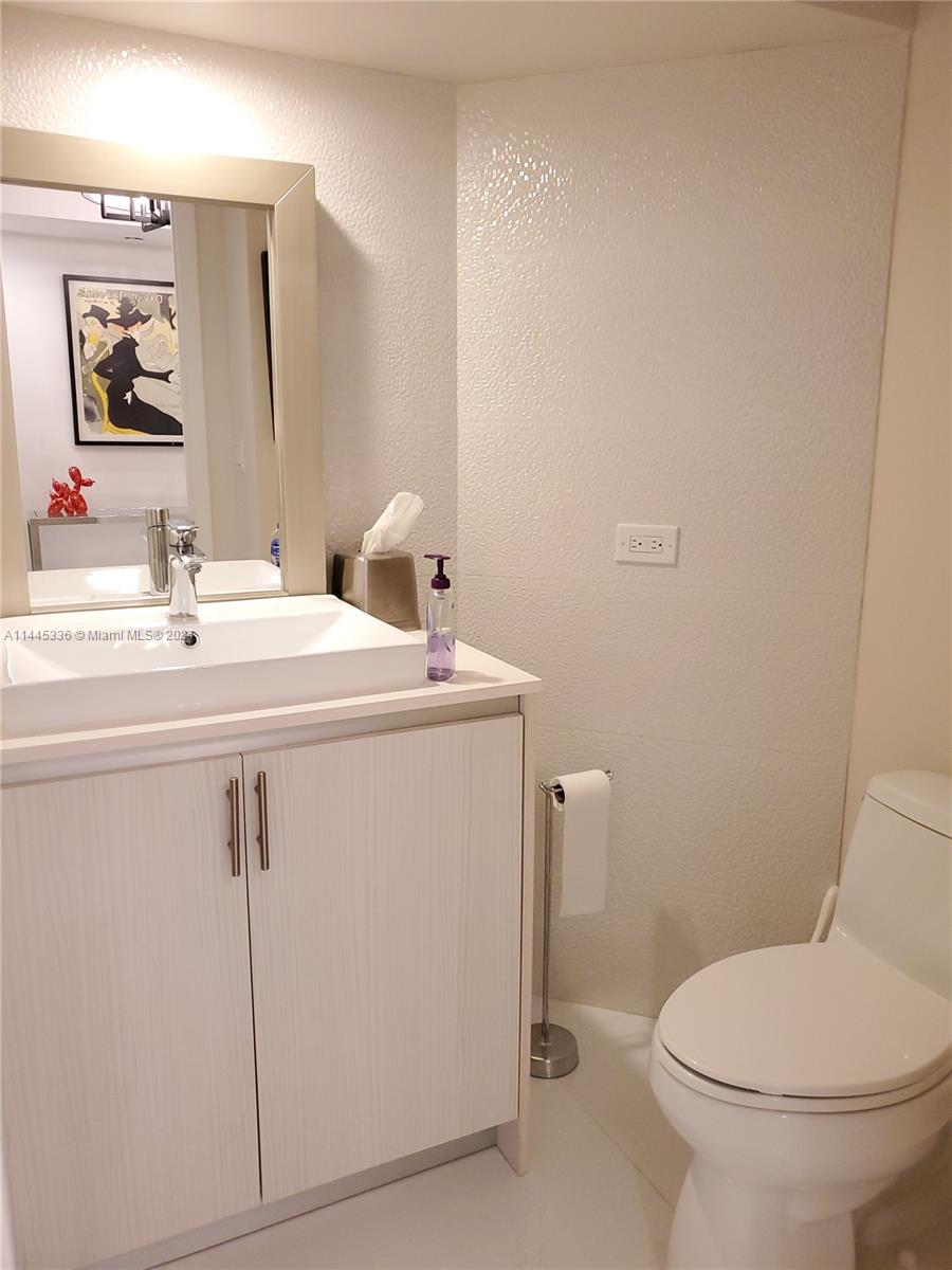 3000 Island Boulevard, Unit 2603 Aventura, FL 33160 - Photo 10 of 28 a bathroom with a sink a toilet and mirror