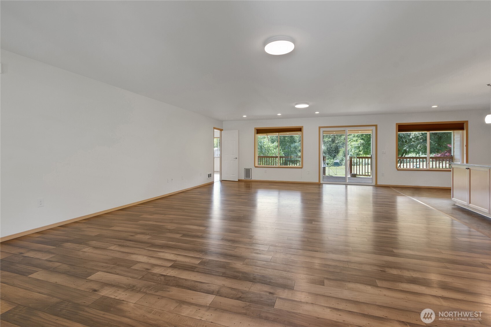 1450 Southeast Spruce Road Port Orchard, WA 98367 - Photo 5 of 39 an empty room with wooden floor and windows
