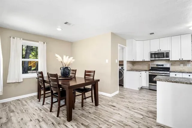 a kitchen with kitchen island granite countertop wooden floors and white appliances