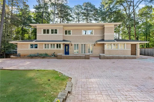 a front view of a house with a yard and trees