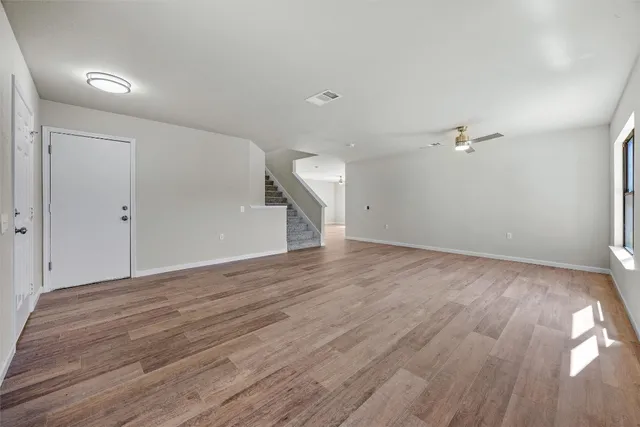 a view of a room with wooden floor and white walls