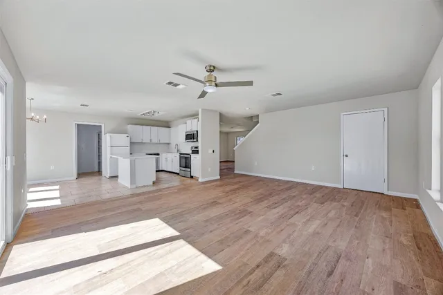 a view of a kitchen with wooden floor and a ceiling fan