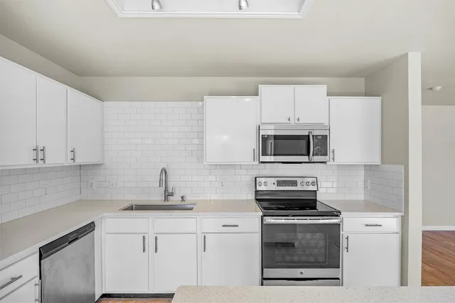 a kitchen with stainless steel appliances a stove a sink and a microwave
