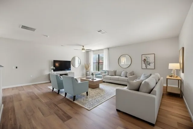 a living room with furniture a flat screen tv and a large window