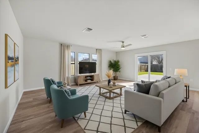 a living room with furniture a flat screen tv and a large window