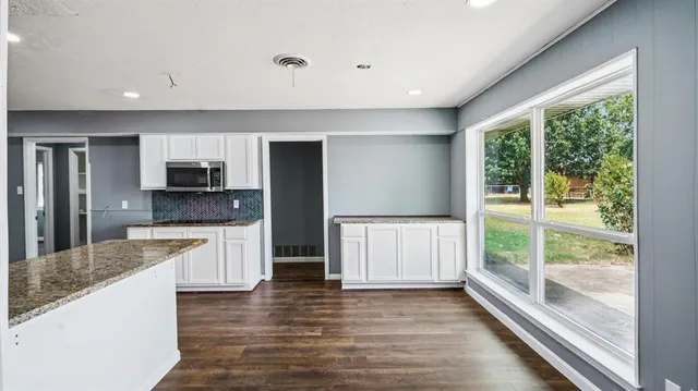 a large kitchen with stainless steel appliances granite countertop a refrigerator and a stove