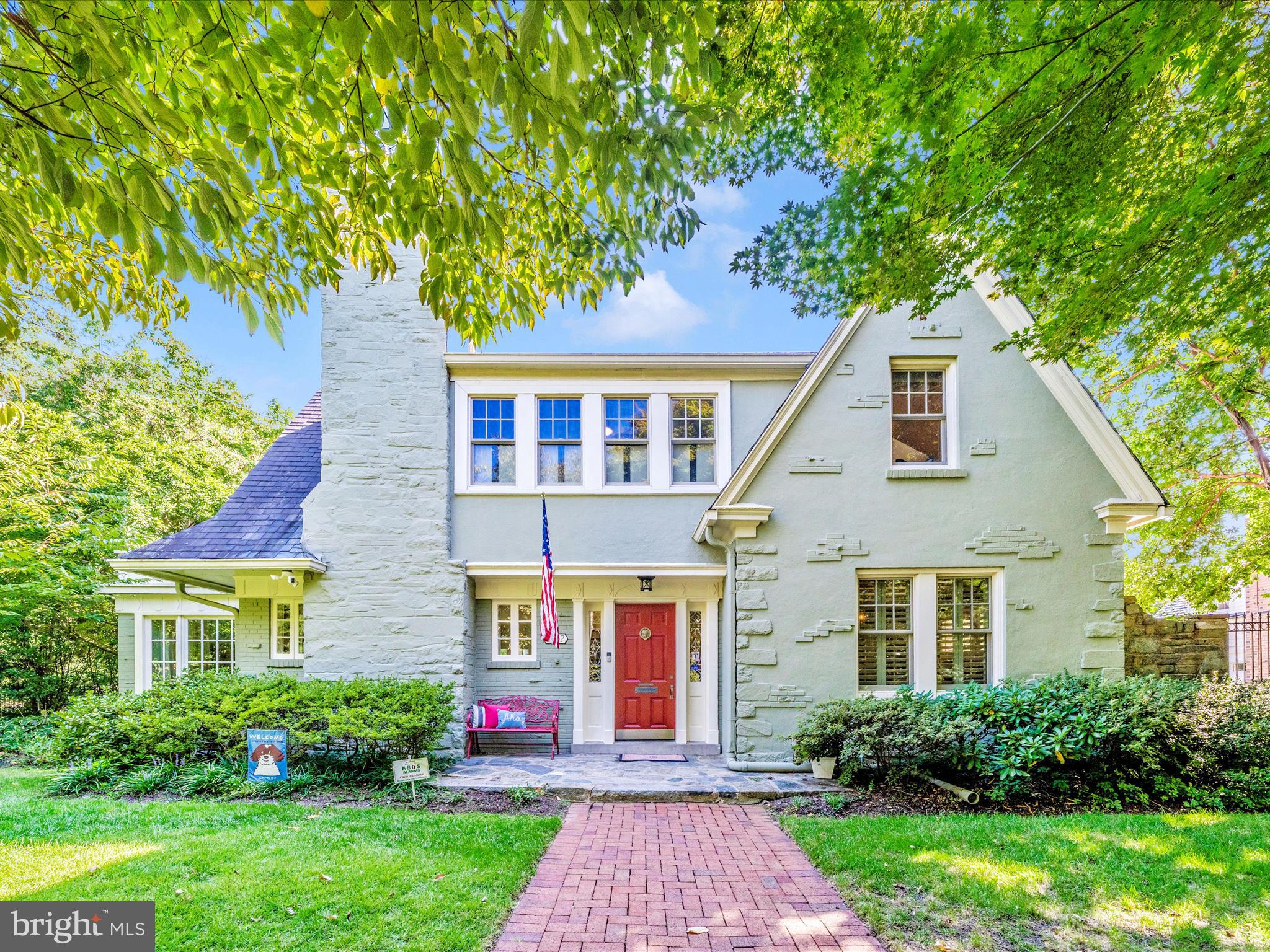 a front view of a house with a yard and trees