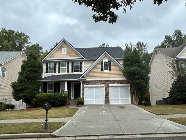 a front view of a house with a yard and garage