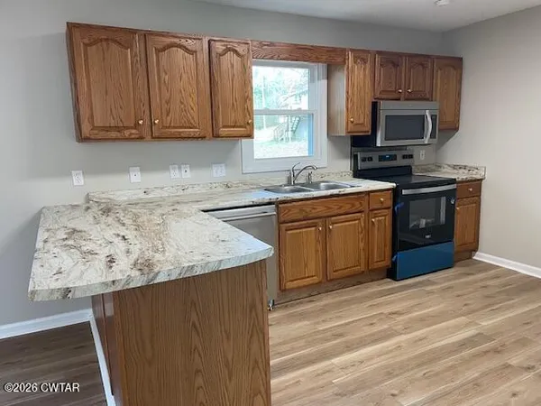 a kitchen with stainless steel appliances granite countertop a stove a sink dishwasher and a microwave oven on the blue kitchen countertops