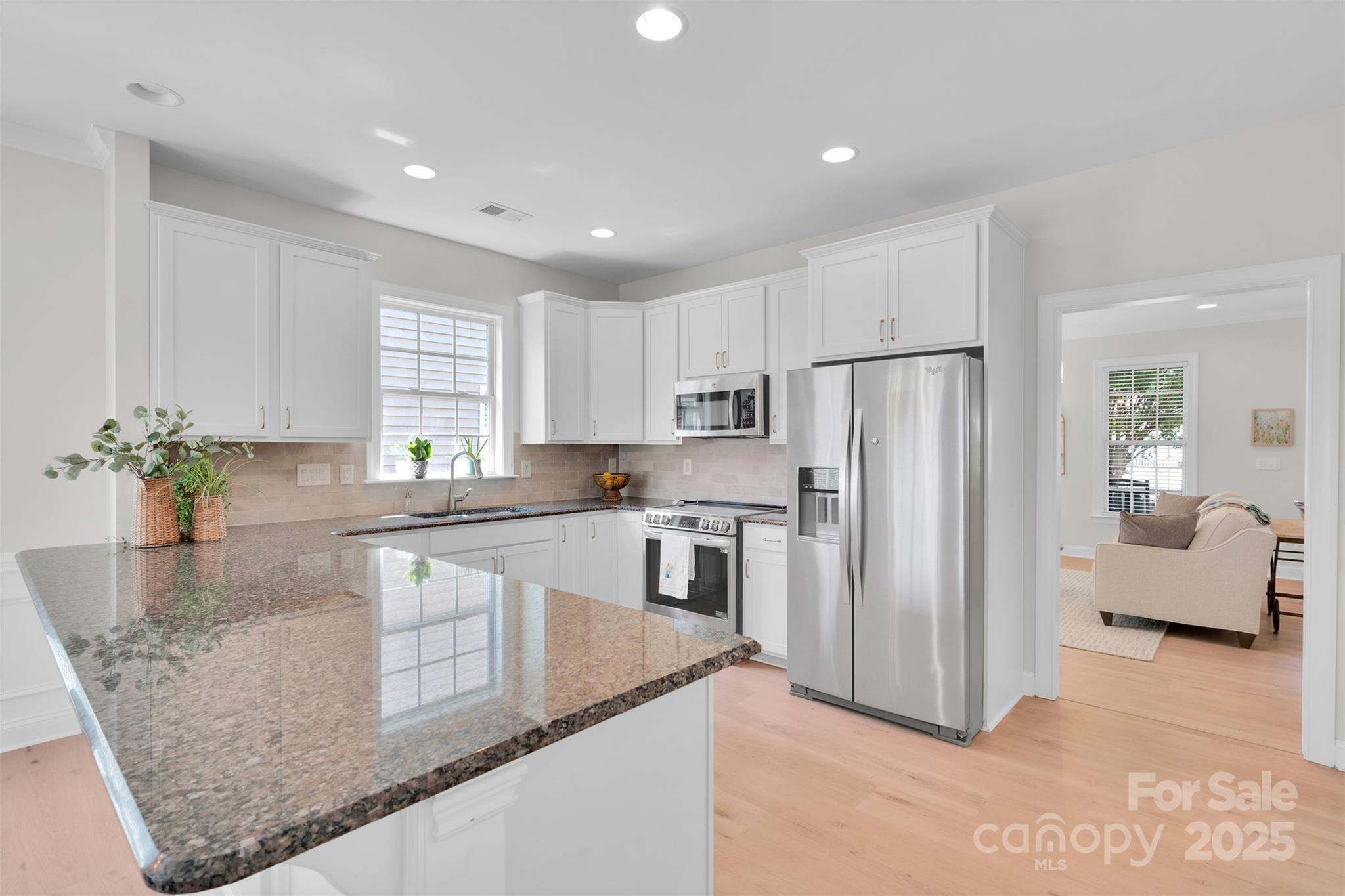 13415 Hazelbrook Lane Cornelius, NC 28031 - Photo 8 of 29 a kitchen with stainless steel appliances granite countertop a refrigerator a sink and white cabinets