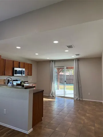 a large kitchen with stainless steel appliances granite countertop a stove and cabinets