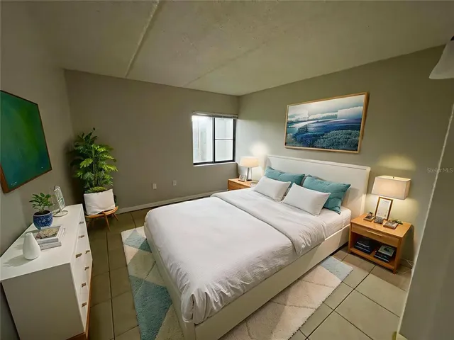 a bedroom with a bed and a potted plant