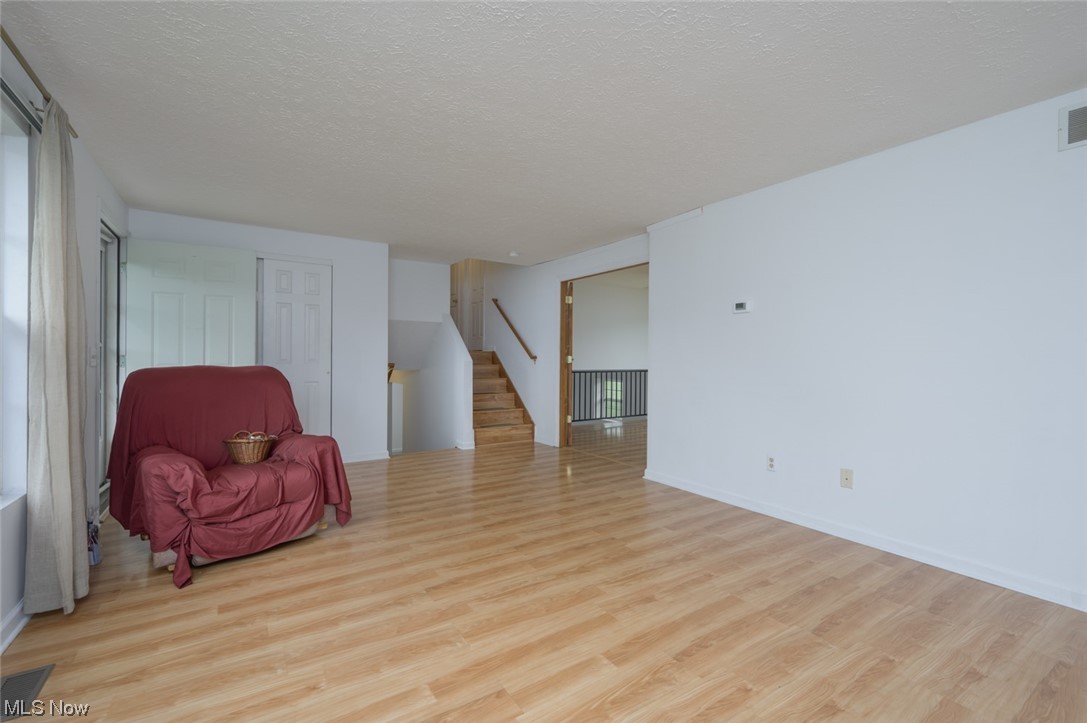 8045 State Rte 5 Ravenna, OH 44266 - Photo 16 of 32 Living area featuring light hardwood flooring and a textured ceiling