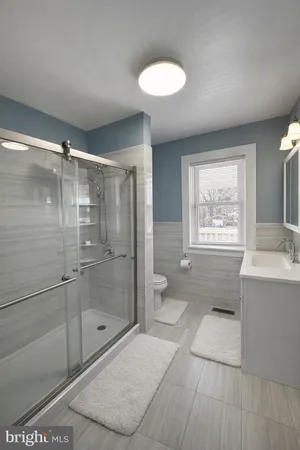a bathroom with a granite countertop sink a toilet and shower