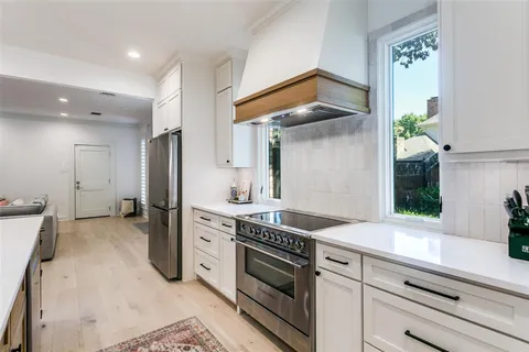 a kitchen with stainless steel appliances white cabinets and a refrigerator