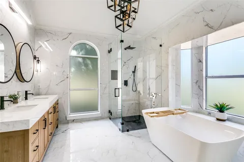 a spacious bathroom with a double vanity sink mirror and shower