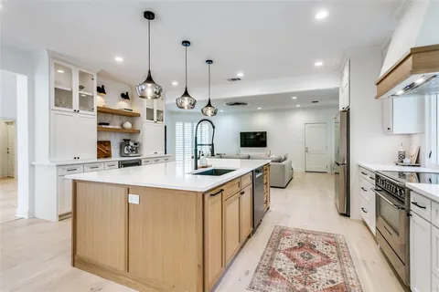 a large kitchen with stainless steel appliances kitchen island a large counter tops and a view of living room