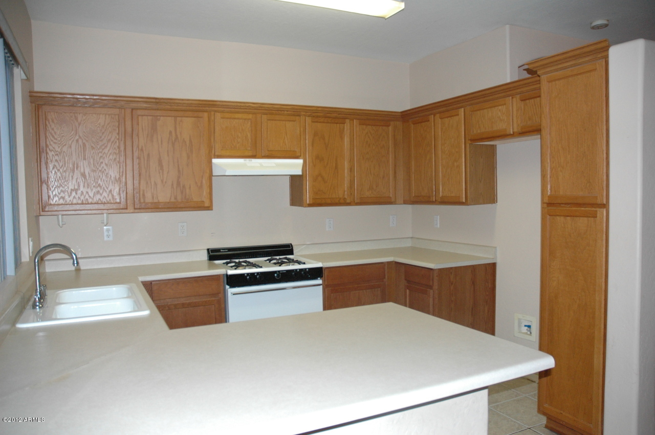 11186 West Berkeley Road Avondale, AZ 85392 - Photo 12 of 15 a kitchen with a sink a stove and cabinets
