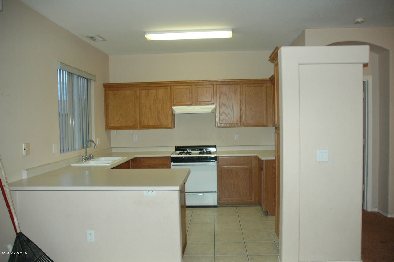 11186 West Berkeley Road Avondale, AZ 85392 - Photo 2 of 15 a kitchen with a stove and a refrigerator