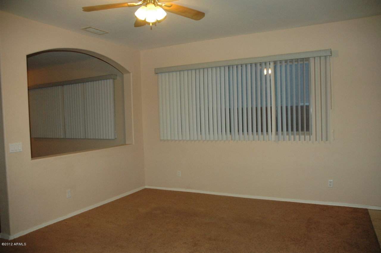 11186 West Berkeley Road Avondale, AZ 85392 - Photo 6 of 15 an empty room with a chandelier fan