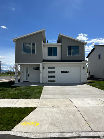 Contemporary two-story residence featuring a gray and white facade with contrasting siding