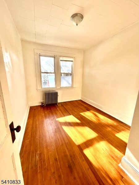 29 Adams Street, Unit 2 Irvington, NJ 07111 - Photo 13 of 14 a view of an empty room with wooden floor and a window