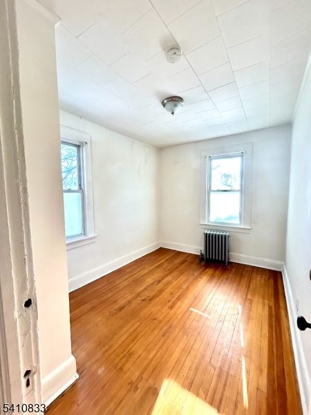 29 Adams Street, Unit 2 Irvington, NJ 07111 - Photo 14 of 14 an empty room with wooden floor and windows