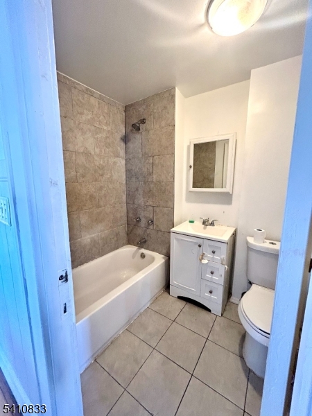 29 Adams Street, Unit 2 Irvington, NJ 07111 - Photo 8 of 14 a bathroom with a sink a toilet a mirror a bathtub and shower