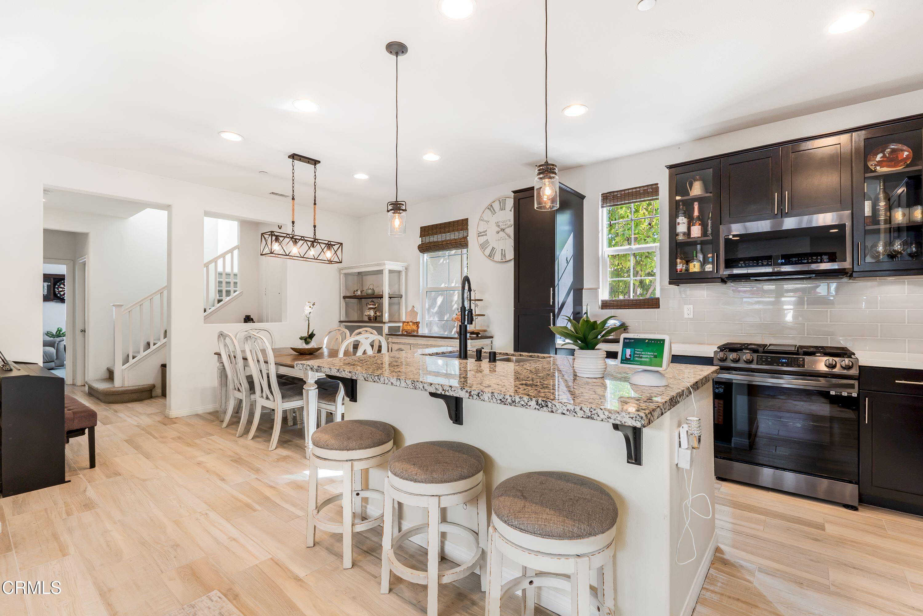 241 Stonegate Road Camarillo, CA 93010 - Photo 7 of 33 a kitchen with stainless steel appliances a dining table chairs stove and sink