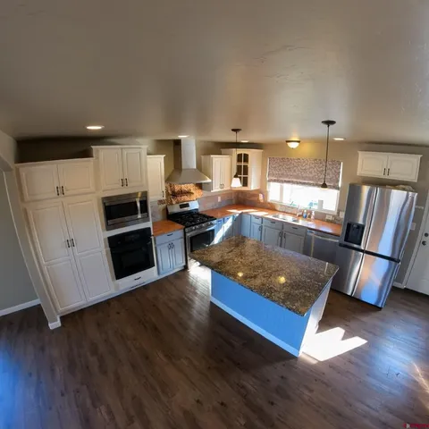a view of a kitchen and a sink wooden floor