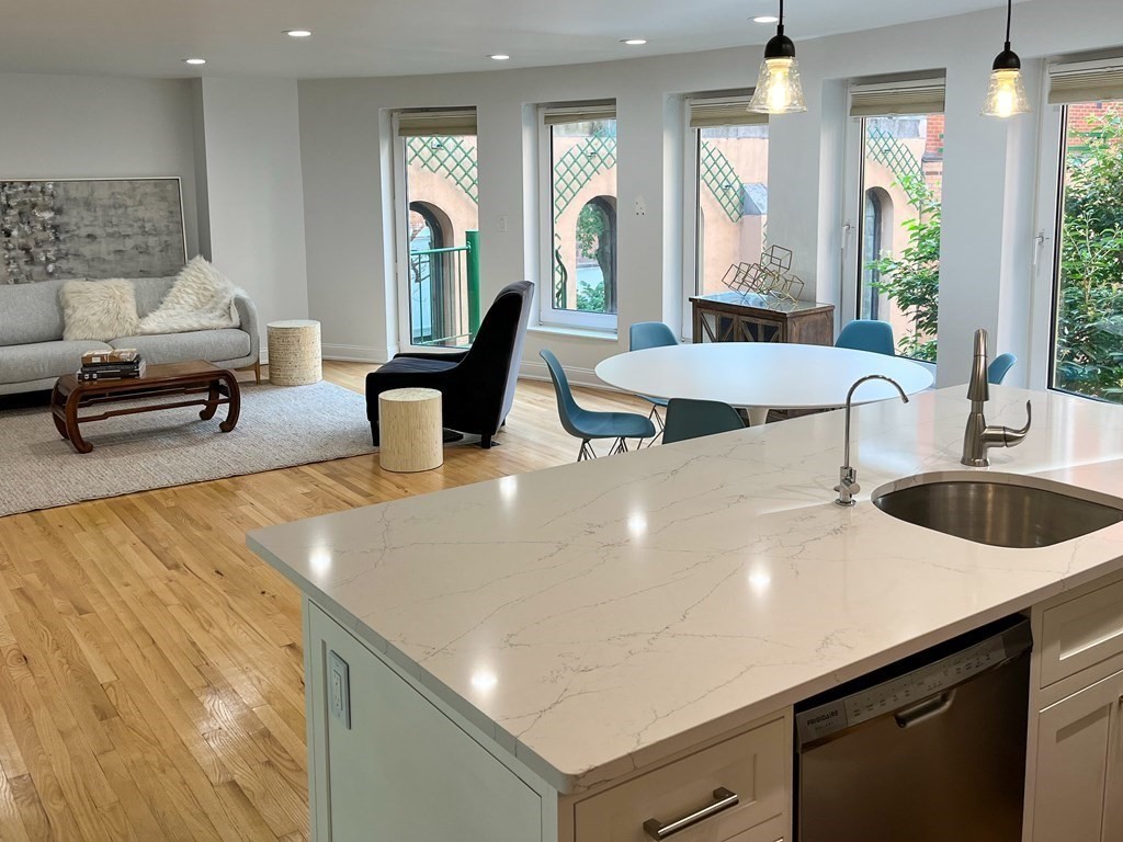 492 Beacon Street, Unit 82 Boston, MA 02115 - Photo 2 of 21 a kitchen with stainless steel appliances a sink a stove and a living room view
