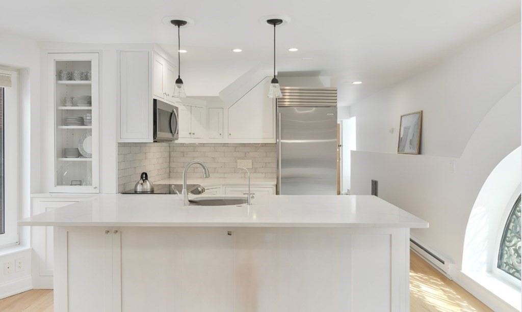 492 Beacon Street, Unit 82 Boston, MA 02115 - Photo 5 of 21 a kitchen with kitchen island a sink a stove a refrigerator and a window