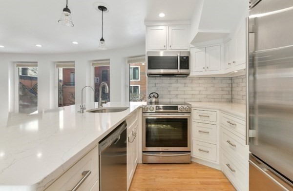 492 Beacon Street, Unit 82 Boston, MA 02115 - Photo 6 of 21 a kitchen with stainless steel appliances granite countertop a stove a sink and a microwave