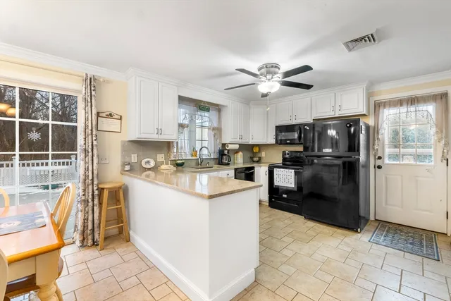 a kitchen with granite countertop a refrigerator a stove a sink a dining table and chairs