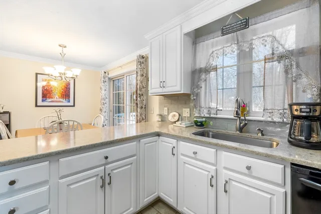 a kitchen with a sink a window and cabinets