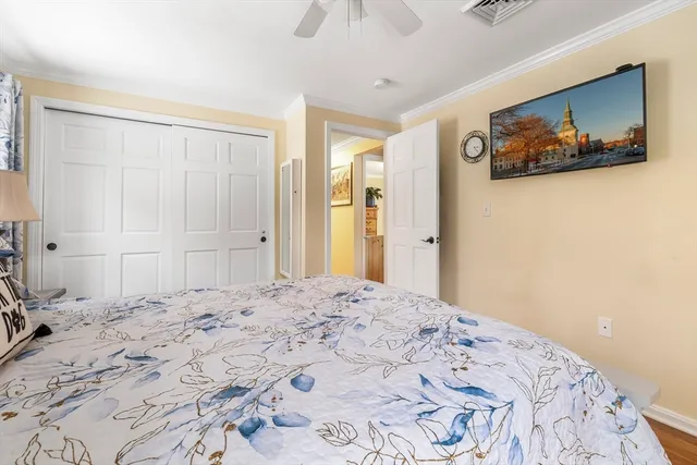 a large bedroom with a bed and painting on the wall