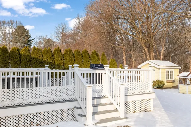 a view of a white house with wooden fence