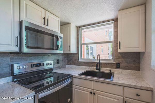 693 Law Street, Unit B Melbourne, FL 32935 - Photo 6 of 8 a kitchen with sink a microwave and cabinets
