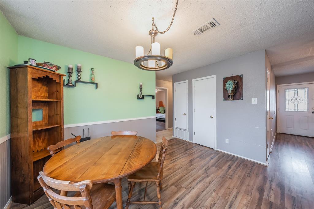 102 Perdue Circle Weatherford, TX 76085 - Photo 12 of 39 a room with a table chairs and wooden floor
