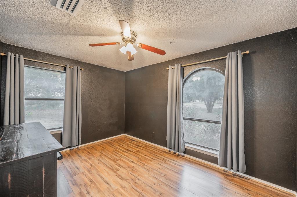 102 Perdue Circle Weatherford, TX 76085 - Photo 13 of 39 a bedroom with wooden floor mirror and windows