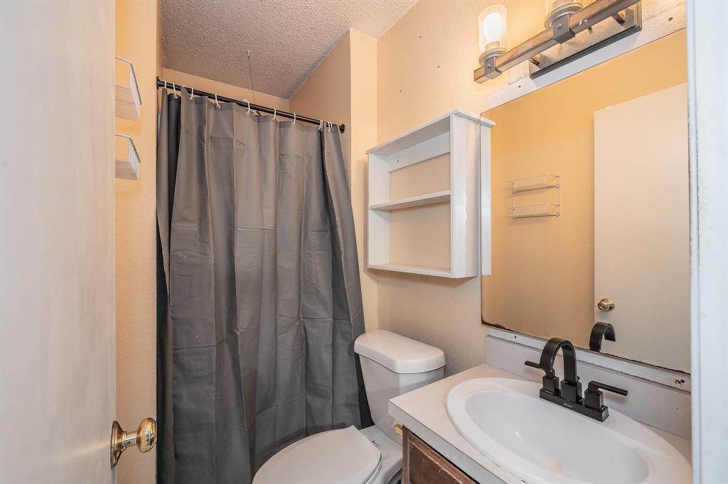 102 Perdue Circle Weatherford, TX 76085 - Photo 17 of 39 a bathroom with a sink a toilet a mirror and shower curtain