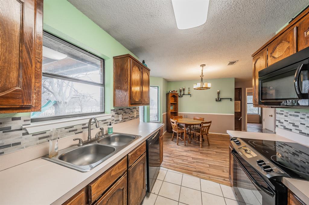 102 Perdue Circle Weatherford, TX 76085 - Photo 8 of 39 a kitchen with stainless steel appliances granite countertop a sink a stove and a refrigerator
