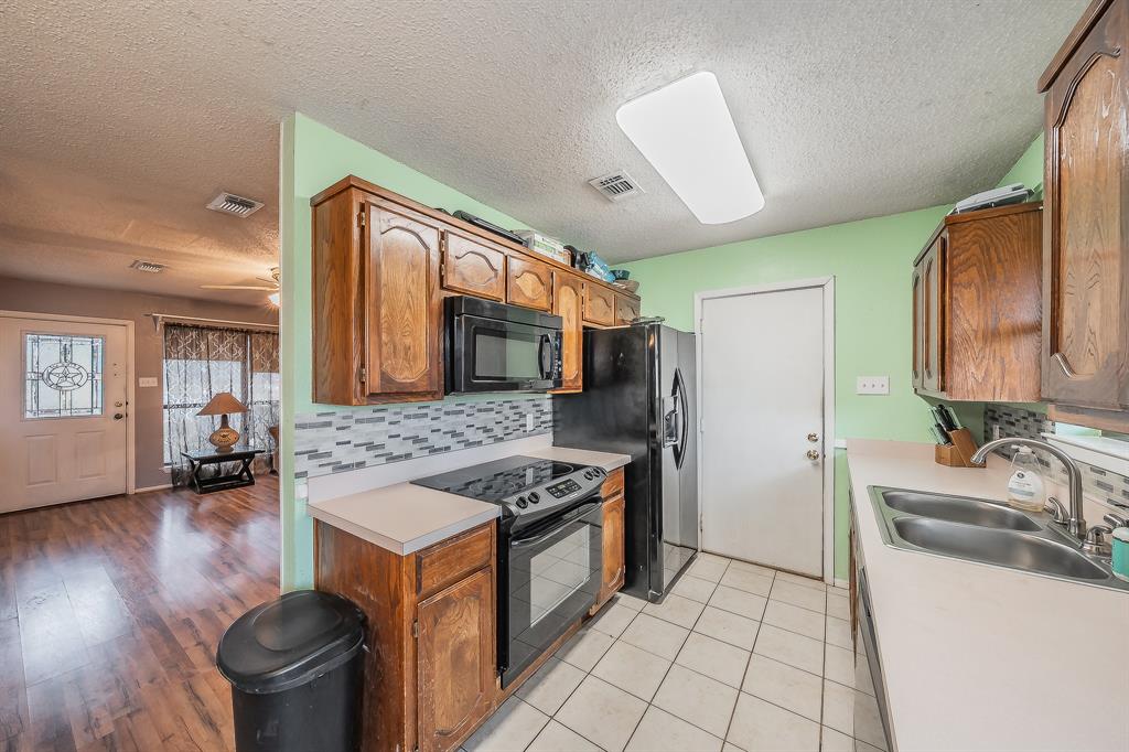 102 Perdue Circle Weatherford, TX 76085 - Photo 9 of 39 a kitchen with stainless steel appliances granite countertop a sink stove and refrigerator