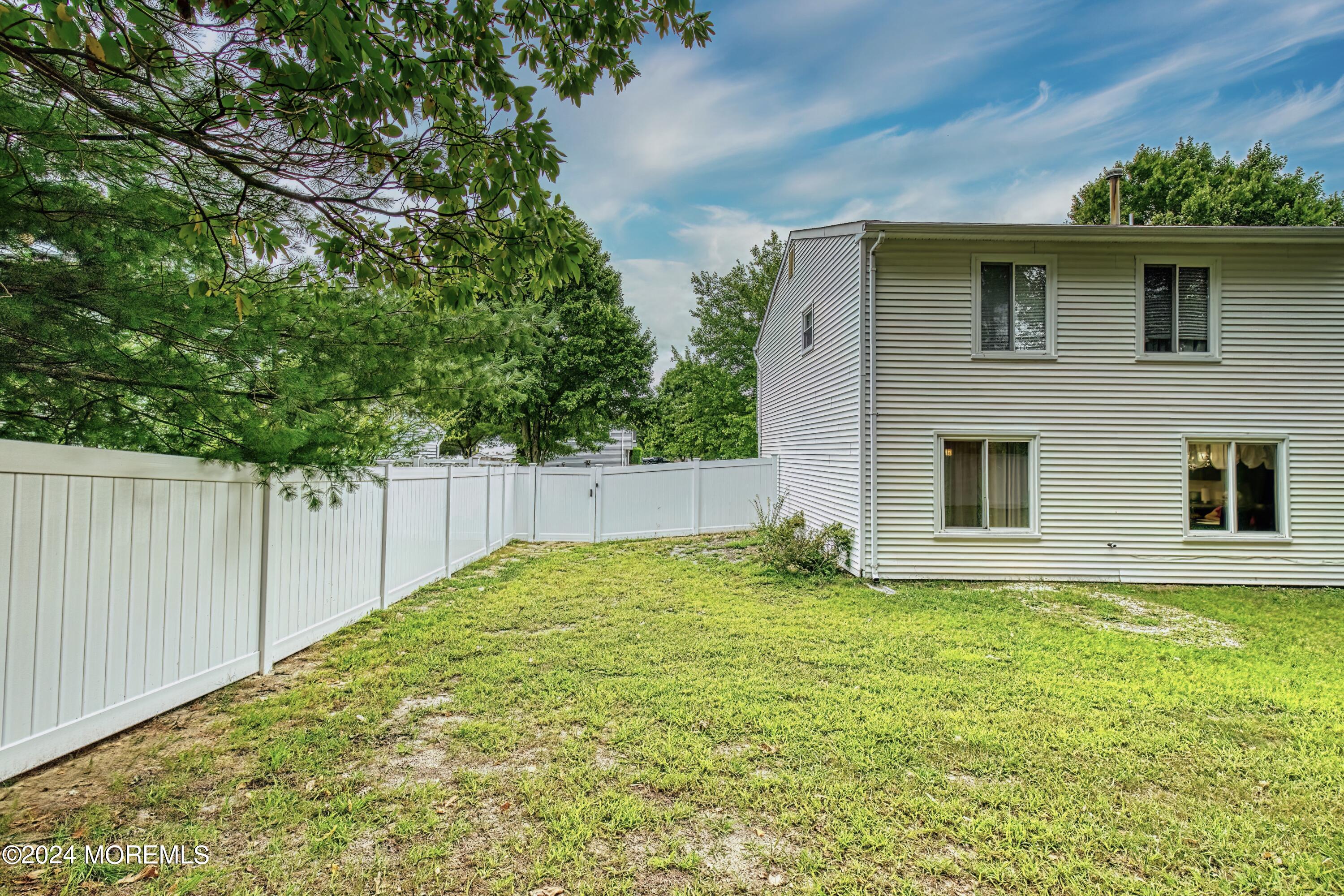 34 Sweetbriar Trail Howell, NJ 07731 - Photo 16 of 53 a backyard of a house with plants and wooden fence