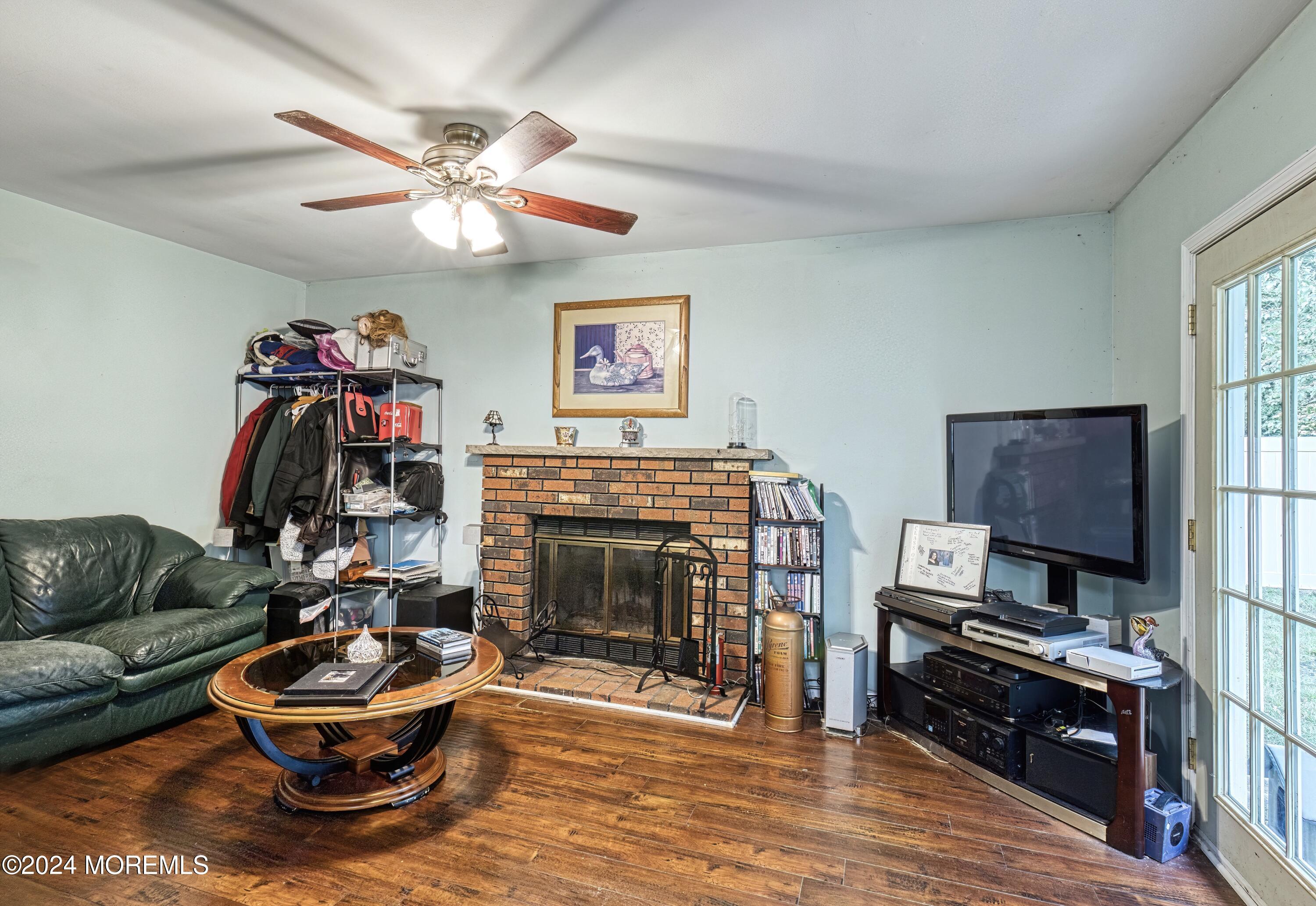 34 Sweetbriar Trail Howell, NJ 07731 - Photo 31 of 53 a living room with furniture a flat screen tv and a fireplace
