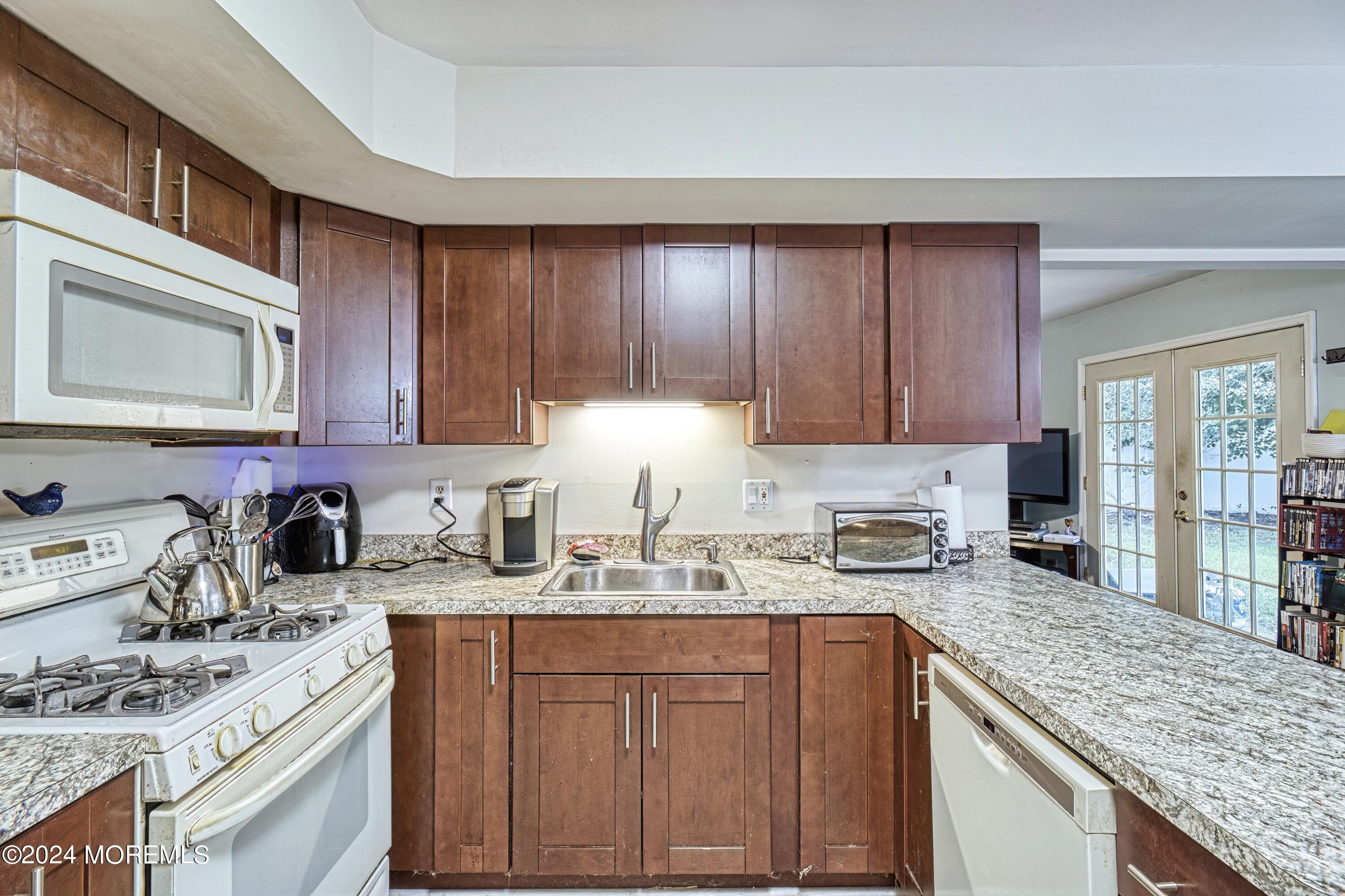 34 Sweetbriar Trail Howell, NJ 07731 - Photo 42 of 53 a kitchen with stainless steel appliances granite countertop a sink stove and cabinets