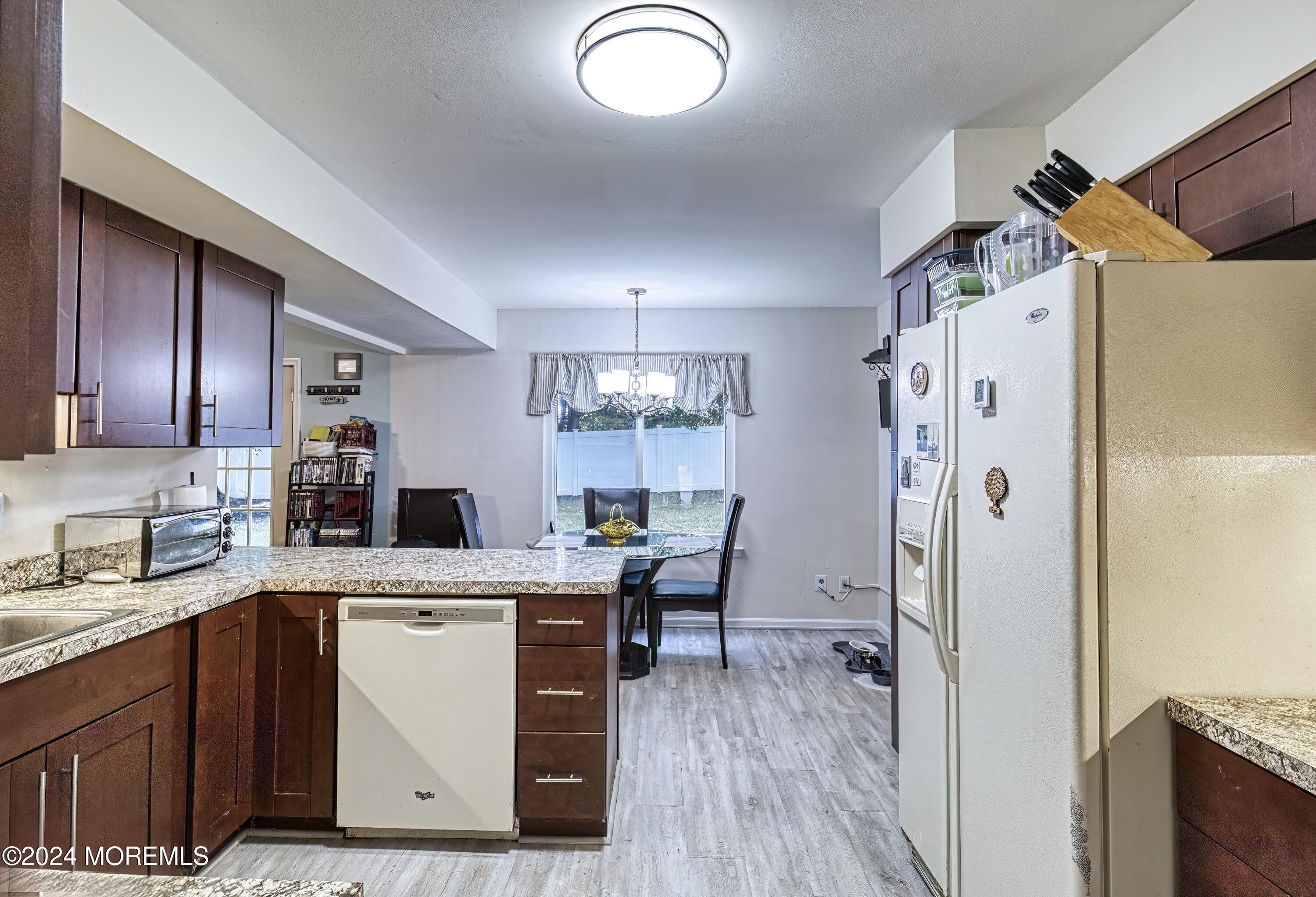 34 Sweetbriar Trail Howell, NJ 07731 - Photo 43 of 53 a kitchen with a table chairs refrigerator and cabinets